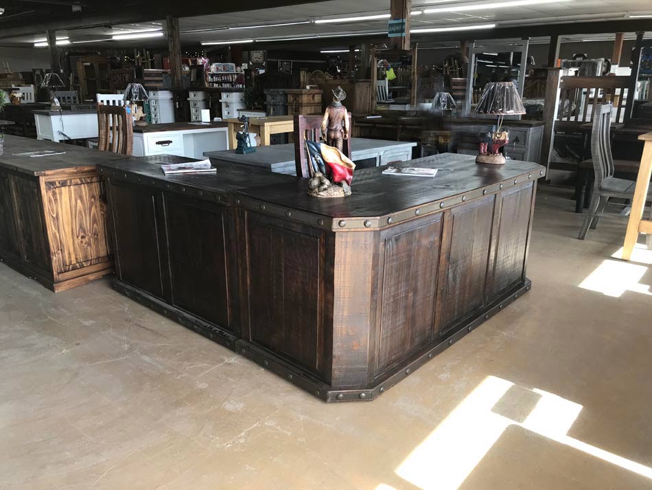 Large dark-stained executive desk with rustic finish and brad accents.