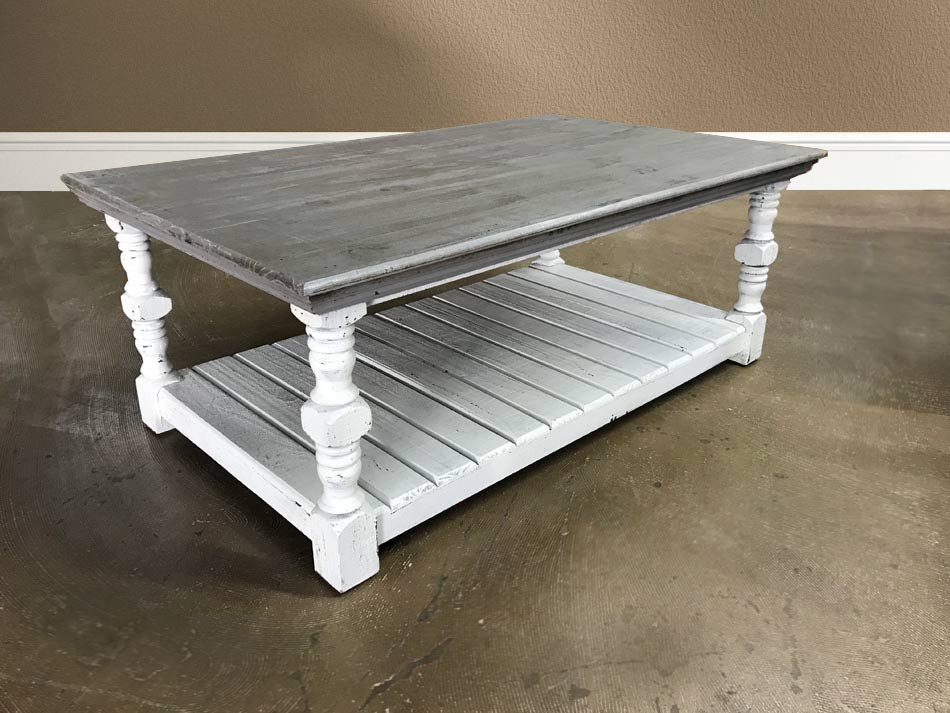 Angle view of white and gray rustic coffee table, with lower slatted shelf.