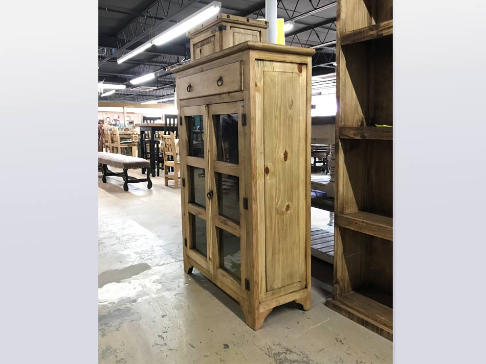 Side view of rustic glass-pane door storage cabinet, in light honey finish.